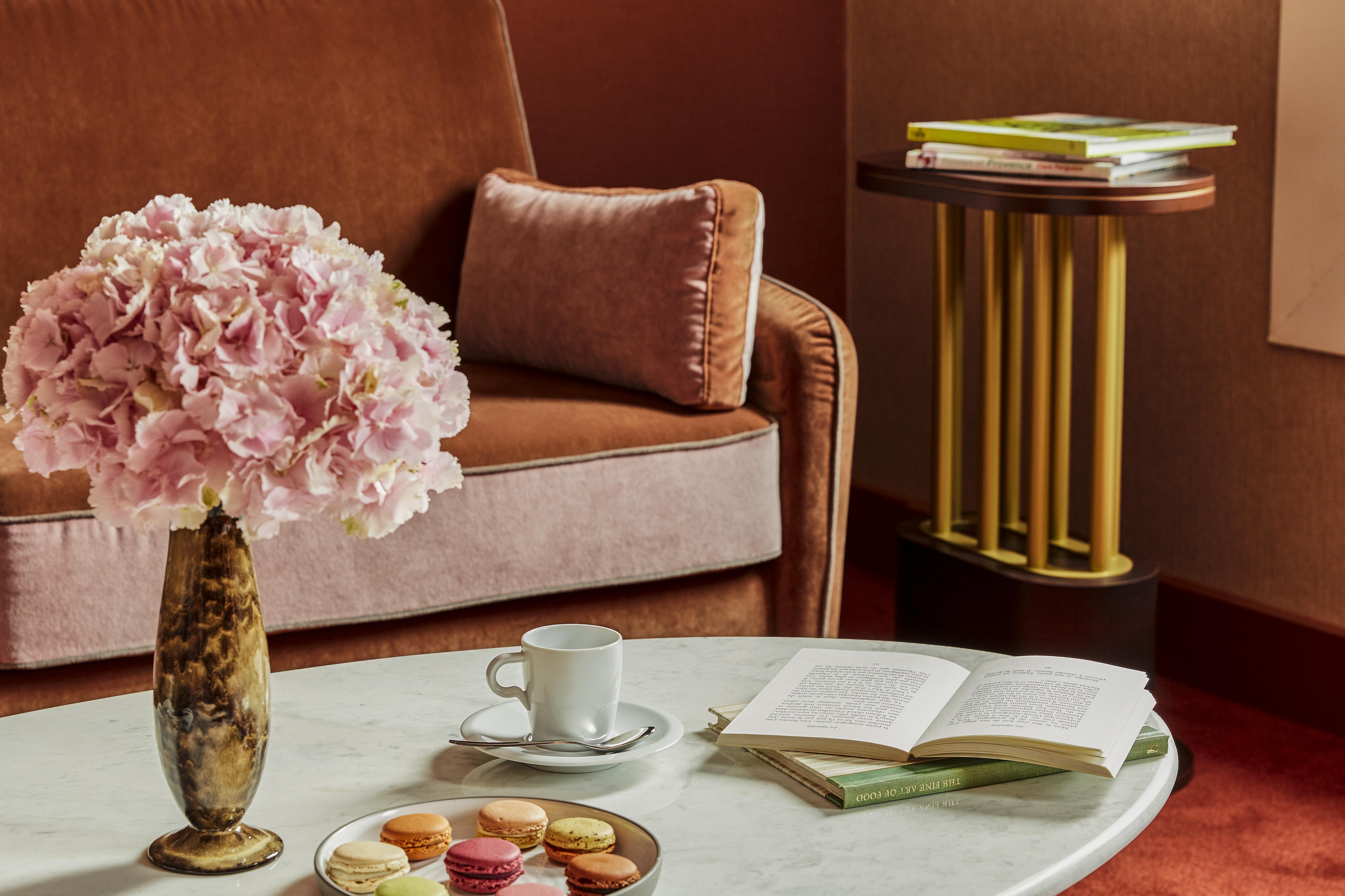 Nest Hotel Paris La Defense - Mgallery Collection Puteaux Exteriér fotografie A table with a coffee cup and saucer, a book, and a vase of flowers